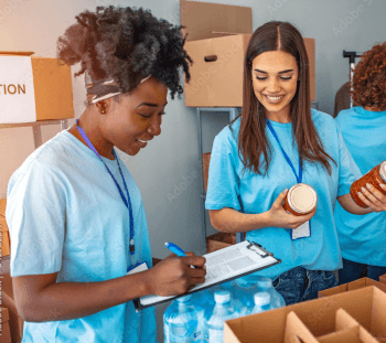 two girls helping pack food boxes at a volunteer event